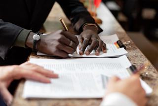 Conciliateur de justice : préalable obligatoire, gratuité et force exécutoire de l'accord Table de réunion avec des documents et deux personnes qui signent un accord
